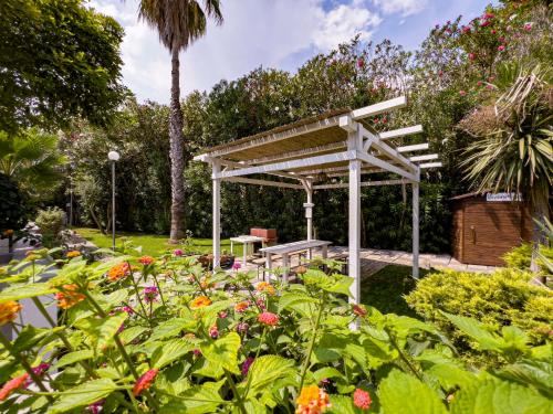 a pergola in a garden with flowers at Residence Borgo Latino- Localo in Torre dell'Orso