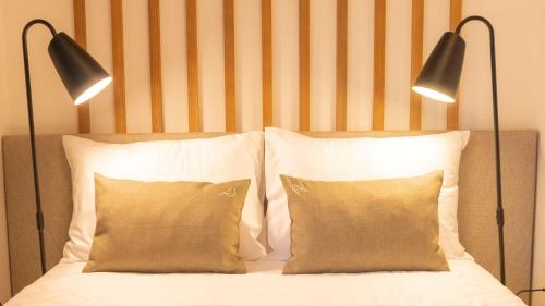 two lamps above a bed with two pillows at Boutique Hotel Soyka in Špindlerův Mlýn