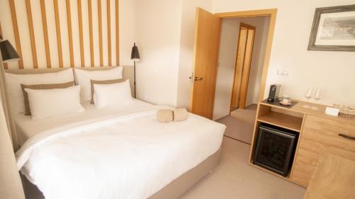 a bedroom with a large white bed and a fireplace at Boutique Hotel Soyka in Špindlerův Mlýn