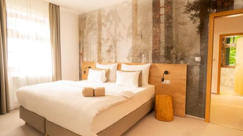 a bedroom with a large white bed with white pillows at Boutique Hotel Soyka in Špindlerův Mlýn