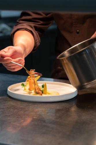 a person eating a plate of food on a table at Naturresort PURADIES in Leogang