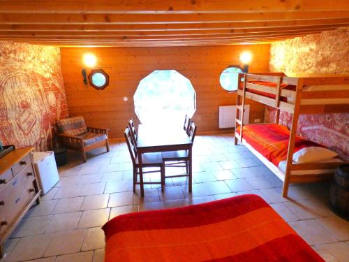 a room with two bunk beds and a table and chairs at Domaine du Balbuzard in Condat-en-Combraille