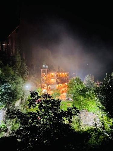 a building in the middle of a park at night at Karakorum View Hotel Karimabad Hunza in Hunza