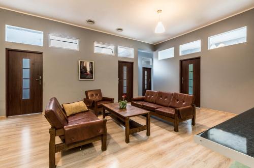 a living room with leather furniture and windows at Tanie spanie przy Malcie - Zameldowanie bezobsługowe - in Poznań