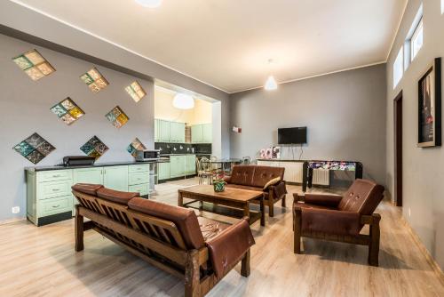 a living room with chairs and a table and a kitchen at Tanie spanie przy Malcie - Zameldowanie bezobsługowe - in Poznań