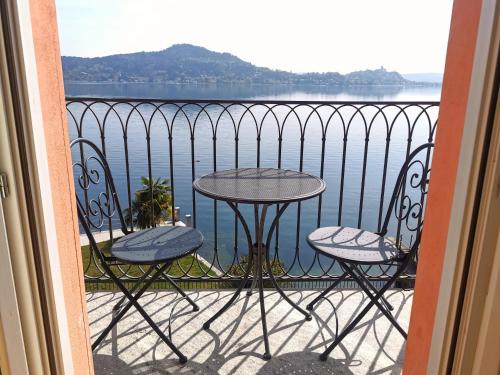 un tavolo e sedie su un balcone con vista sull'acqua di Resort Antico Verbano a Meina
