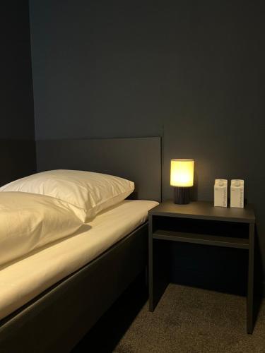 a bedroom with a bed and a lamp on a night stand at Hotel Maritime in Copenhagen