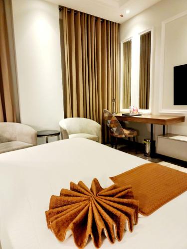 a hotel room with a bed with a brown bow on it at Best Western Premier Hotel Gulberg Lahore in Lahore