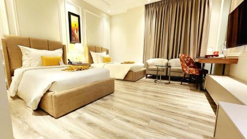 a hotel room with two beds and a desk at Best Western Premier Hotel Gulberg Lahore in Lahore