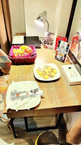 a wooden table with two plates of food on it at Best Western Premier Hotel Gulberg Lahore in Lahore