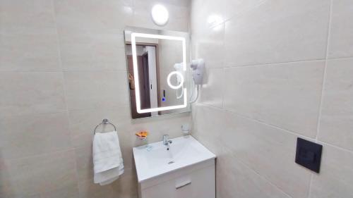 a white bathroom with a sink and a mirror at Las Victorias Suites Bariloche in San Carlos de Bariloche