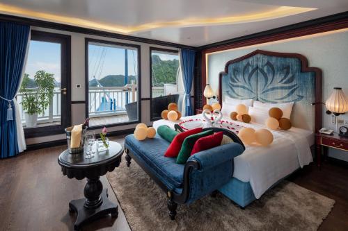 ein Schlafzimmer mit einem großen Bett und einem blauen Sofa in der Unterkunft Verdure Lotus Cruises in Hạ Long
