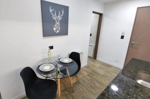 a dining room with a glass table and two chairs at Las Victorias Suites Bariloche in San Carlos de Bariloche