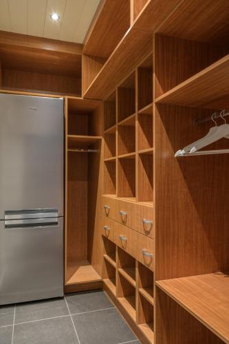 a kitchen with a refrigerator and wooden cabinets at De Vesten Comfort Lodge in Laakdal