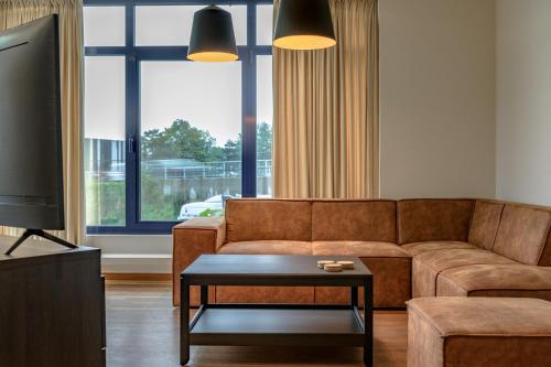 a living room with a couch and a tv at De Vesten Comfort Lodge in Laakdal