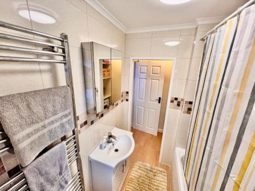 La salle de bains est pourvue d'un lavabo et d'une douche. dans l'établissement Guest House Rooms Birmingham, à Birmingham