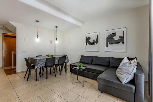 uma sala de estar com um sofá e uma mesa em Tenerifeopenhome Townhouse Oasis Fañabe 21 em Adeje