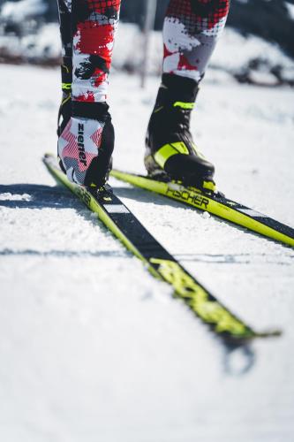 a person is standing on skis in the snow at Hotel Fischer am See in Heiterwang