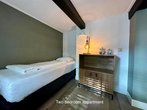 a small bedroom with a bed and a dresser at Appartementen in het centrum van Hoorn in Hoorn