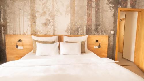 a bed with white sheets and pillows in a bedroom at Boutique Hotel Soyka in Špindlerův Mlýn
