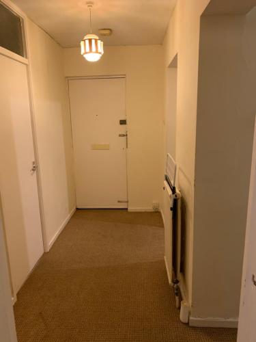 an empty hallway with a white door and a hallway at 39 Abbey Court Coventry in Whitley