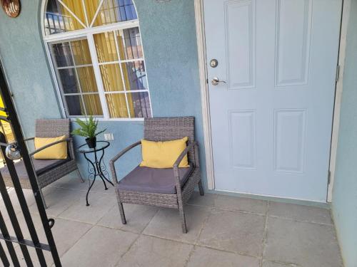 a chair with a yellow pillow sitting on a porch at Sunset Paradise Home in Discovery Bay