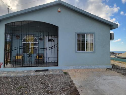 a blue house with a gate in front of it at Sunset Paradise Home in Discovery Bay