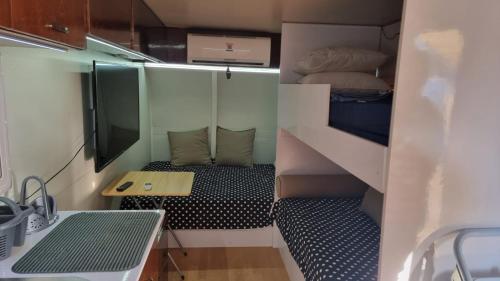 Kleines Zimmer mit einem Bett und einem Tisch in der Unterkunft קרוון in Eilat