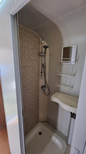ein Bad mit einer Dusche und einem Waschbecken in der Unterkunft קרוון in Eilat