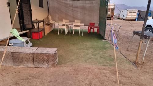 eine Gruppe von Tischen und Stühlen in einem Zelt in der Unterkunft קרוון in Eilat