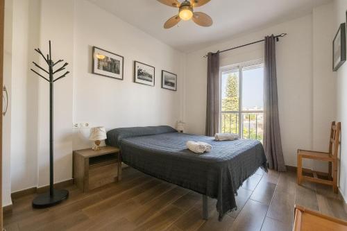a bedroom with a bed and a window at Duplex Near the Beach in Chiclana de la Frontera