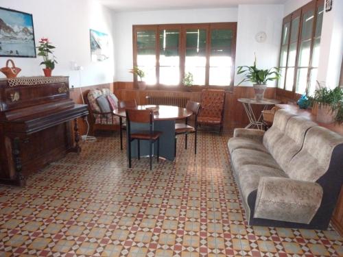 a living room with a couch and a piano at Pensión Fonda Vilalta in Ribes de Freser