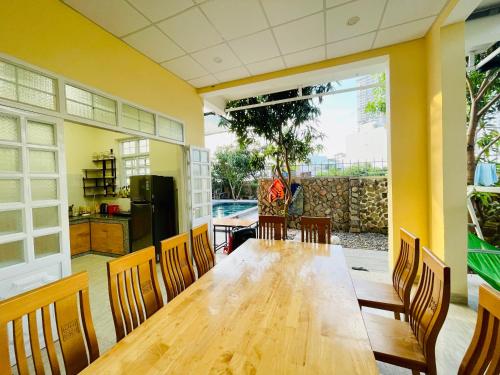 - une salle à manger avec une table et des chaises en bois dans l'établissement Garden House Nha Trang, à Nha Trang