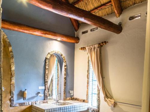 a bathroom with a sink and a mirror at Malandela's Guest House in Malkerns