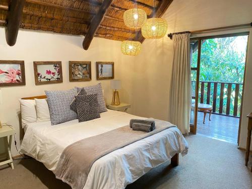 a bedroom with a large bed and a balcony at Malandela's Guest House in Malkerns