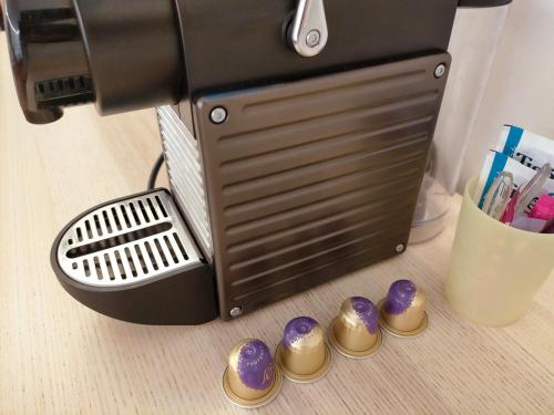 a coffee maker with gold and purple buttons on a table at Jacuzzi LOVE Suite in Paris