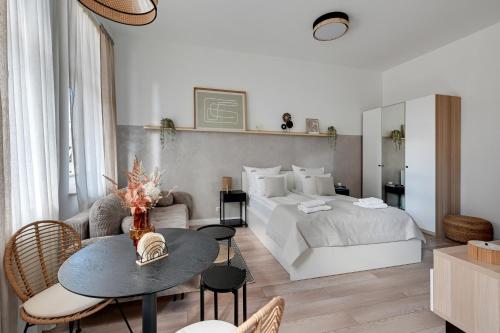 a bedroom with a bed and a table and chairs at Downtown Apartments Chmielna Park - City Center & Parking in Gdańsk