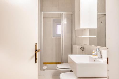 bagno bianco con lavandino e servizi igienici di Padova Centre Cosy Apartment a Padova