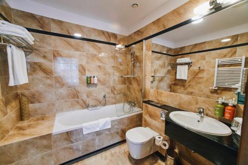 La salle de bains est pourvue d'une baignoire, de toilettes et d'un lavabo. dans l'établissement Holiday Inn Krakow City Centre, an IHG Hotel, à Cracovie