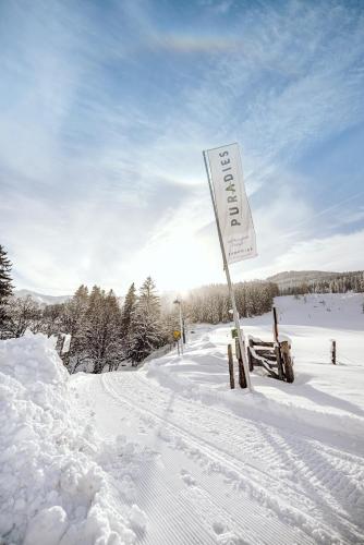 a snow covered road with a sign in the snow at Naturresort PURADIES in Leogang