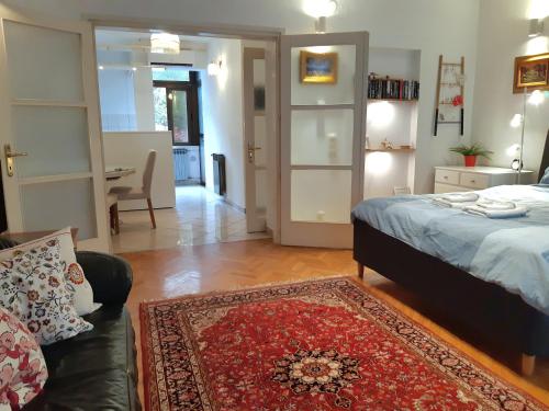 a bedroom with a bed and a couch and a rug at My Miracle Apartment in Zagreb