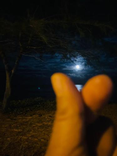 a person with their hand up in the dark at Paka Tamim Seaview Hotel in Paka
