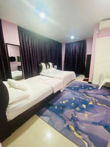 a bedroom with two beds and a world rug at Paka Tamim Seaview Hotel in Paka