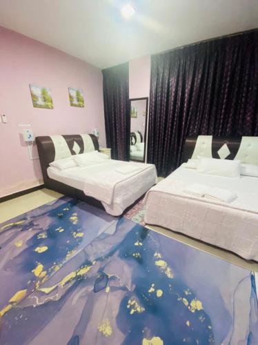 a bedroom with two beds and a carpeted floor at Paka Tamim Seaview Hotel in Paka