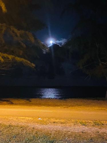 a moonlight over a body of water at night at Paka Tamim Seaview Hotel in Paka