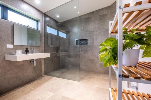 W łazience znajduje się prysznic, umywalka i lustro. w obiekcie At The Bay w mieście Coles Bay