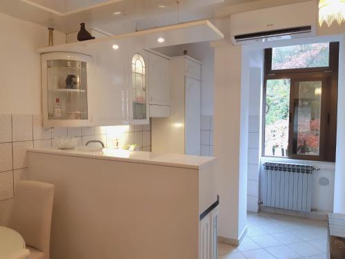 a white kitchen with a sink and a window at My Miracle Apartment in Zagreb