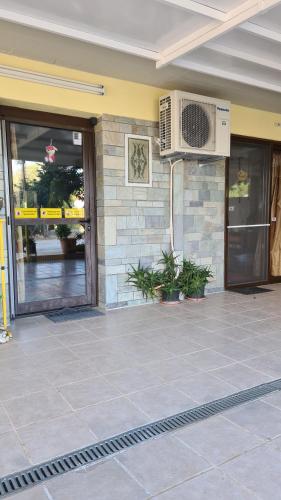 a building with a patio with a fan on the wall at Villa George - Family Holidays in Nea Makri