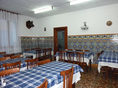 a dining room with two tables and chairs with blue and white at Pensión Fonda Vilalta in Ribes de Freser