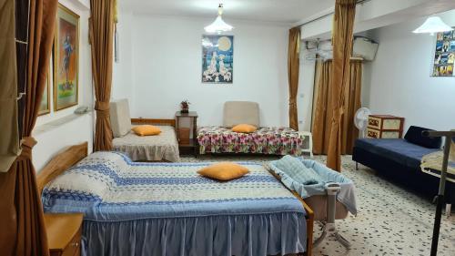 um quarto com duas camas e um sofá em Villa George - Family Holidays em Nea Makri